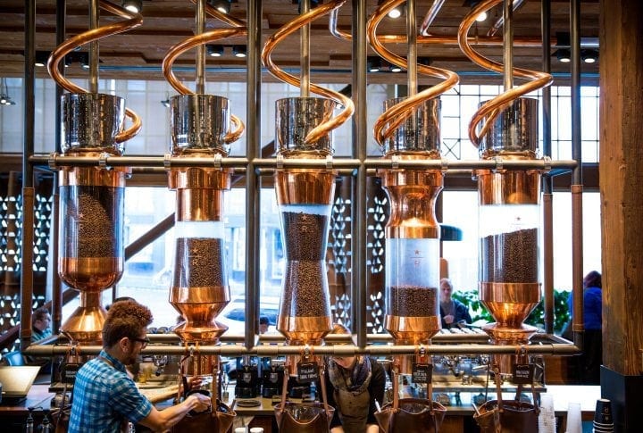 Starbucks is launching a new prestige brand . Image is of a man dispensing coffee