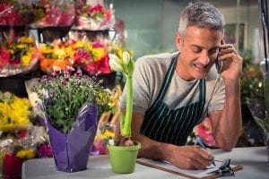 Male florist on the phone taking an critical order Male florist on the phone taking an critical order