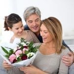 husband and daughter presenting flowers to the wife, mother