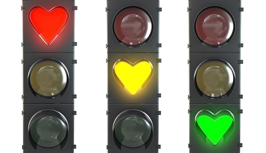 et of traffic light with heart shaped red, yellow and green lamps isolated on white background