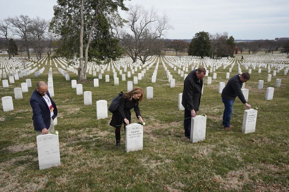 CAD participants pay their respects and place flowers on headstones during a visit to Arlington National Cemetery.